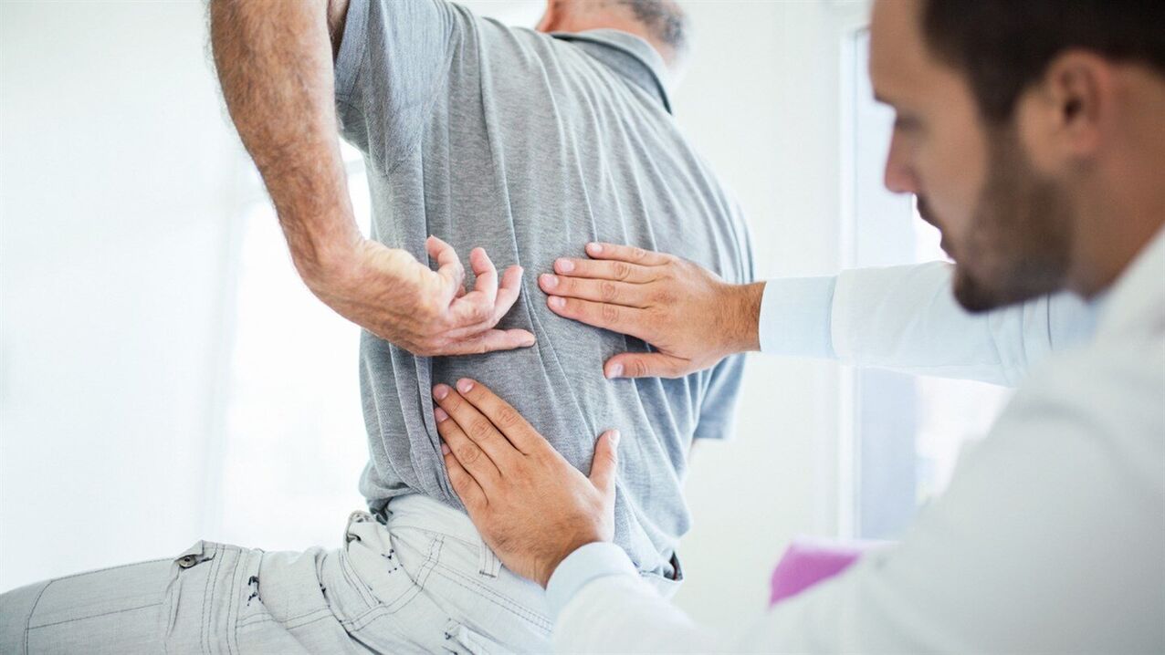 лекар изследва гърба с лумбална остеохондроза